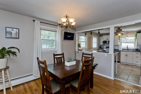 a dining room with furniture potted plants and wooden floor