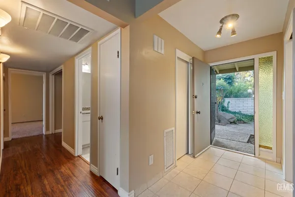 a view of a hallway with wooden floor and a bathroom