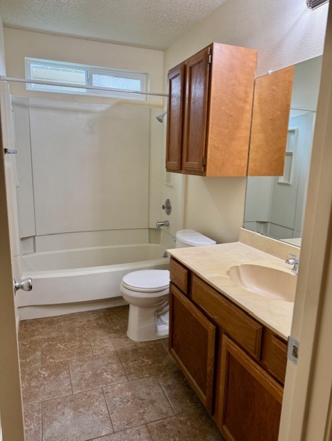 9006 B Sedgemoor Trail Austin, TX 78748 - Photo 11 of 16 Full bathroom with a textured ceiling, vanity, and shower / washtub combination