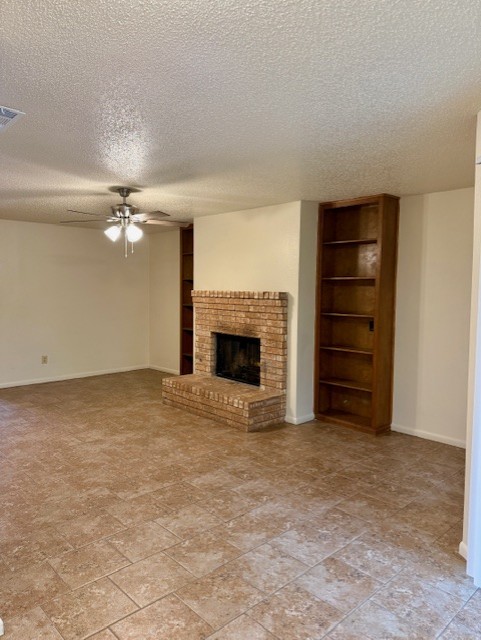 9006 B Sedgemoor Trail Austin, TX 78748 - Photo 4 of 16 Unfurnished living room featuring a fireplace, a textured ceiling, built in features, and a ceiling fan