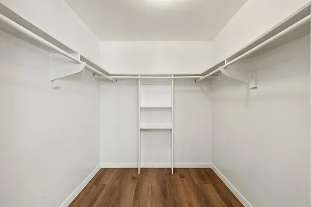 a view of walk in closet with empty racks
