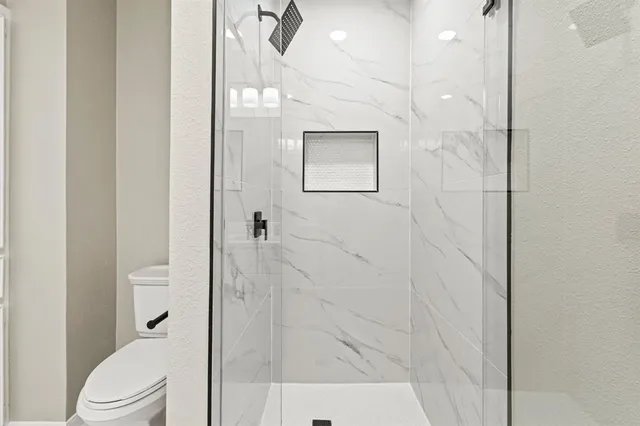 a bathroom with a shower and toilet