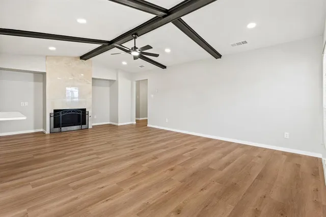 a view of empty room with wooden floor and ceiling fan