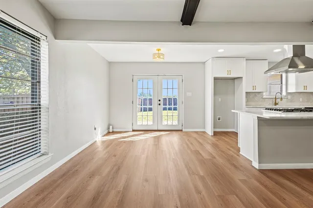 a view of a kitchen with wooden floor and a window
