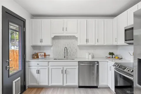 a kitchen with white cabinets and white appliances