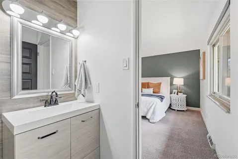 a en suite bathroom with a double vanity sink and a mirror
