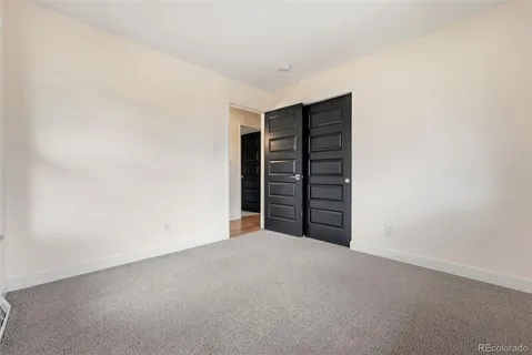 a view of an empty room with stairs and a window