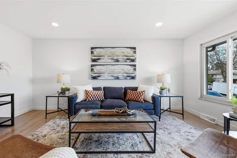 a living room with furniture a lamp a rug and a window