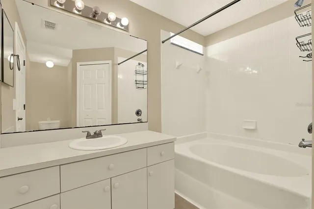 a bathroom with a tub a sink and a mirror