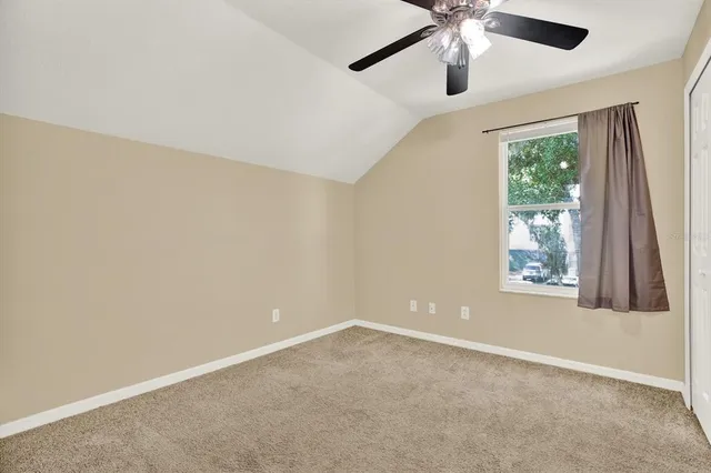 an empty room with a window and a fan