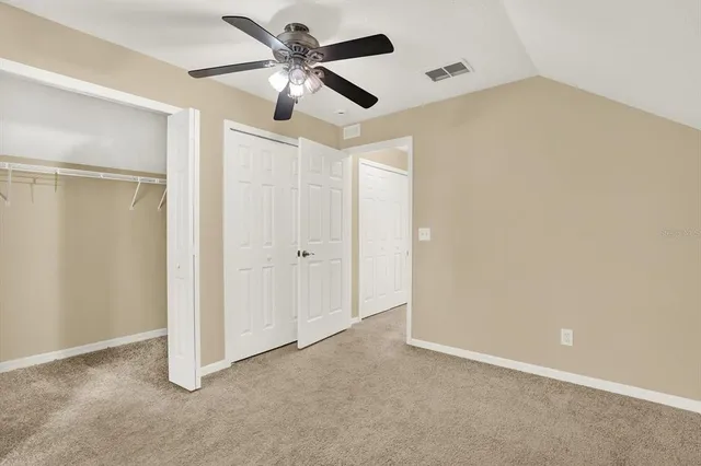 an empty room with a ceiling fan and a window