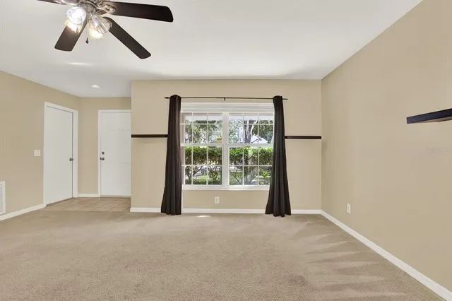 a view of a livingroom with a ceiling fan and window