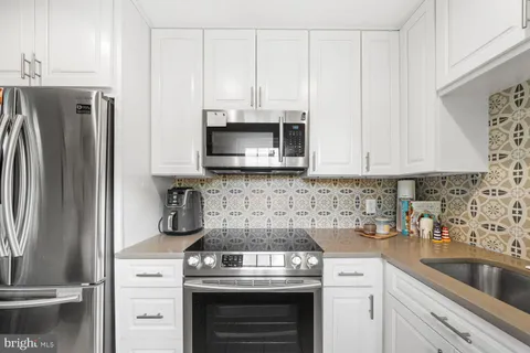 a kitchen with stainless steel appliances granite countertop a sink a stove a microwave and cabinets