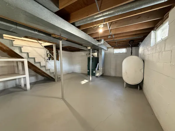 a view of an empty room with wooden floor and windows