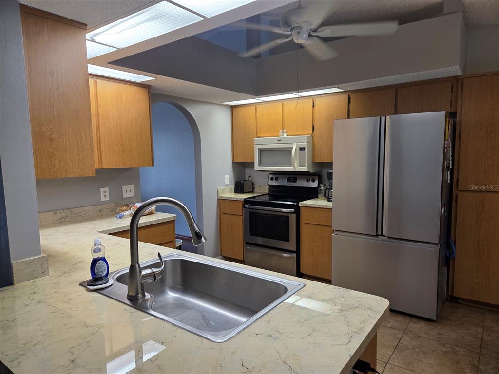 7605 Landmark Drive Spring Hill, FL 34606 - Photo 14 of 26 a kitchen with a refrigerator a sink a stove and cabinets