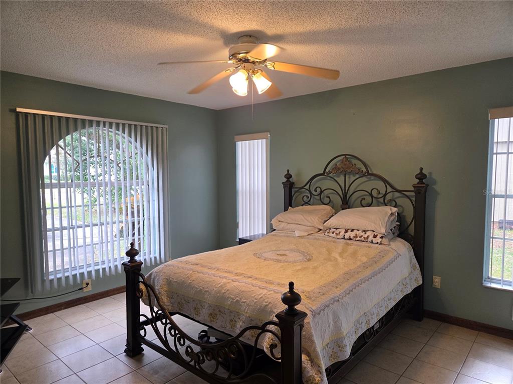 7605 Landmark Drive Spring Hill, FL 34606 - Photo 17 of 26 a bedroom with a bed and a chandelier