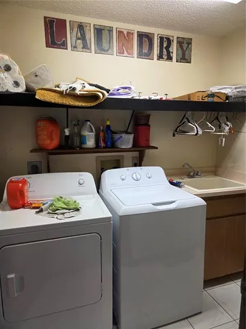 a utility room with lots of clutter and cabinets