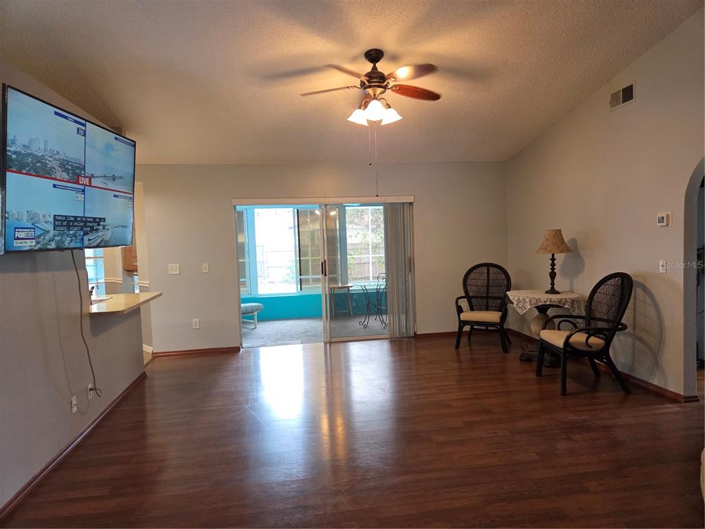 7605 Landmark Drive Spring Hill, FL 34606 - Photo 8 of 26 a view of a livingroom with furniture a ceiling fan and wooden floor