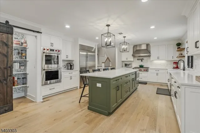 a kitchen with a dining table chairs sink and cabinets