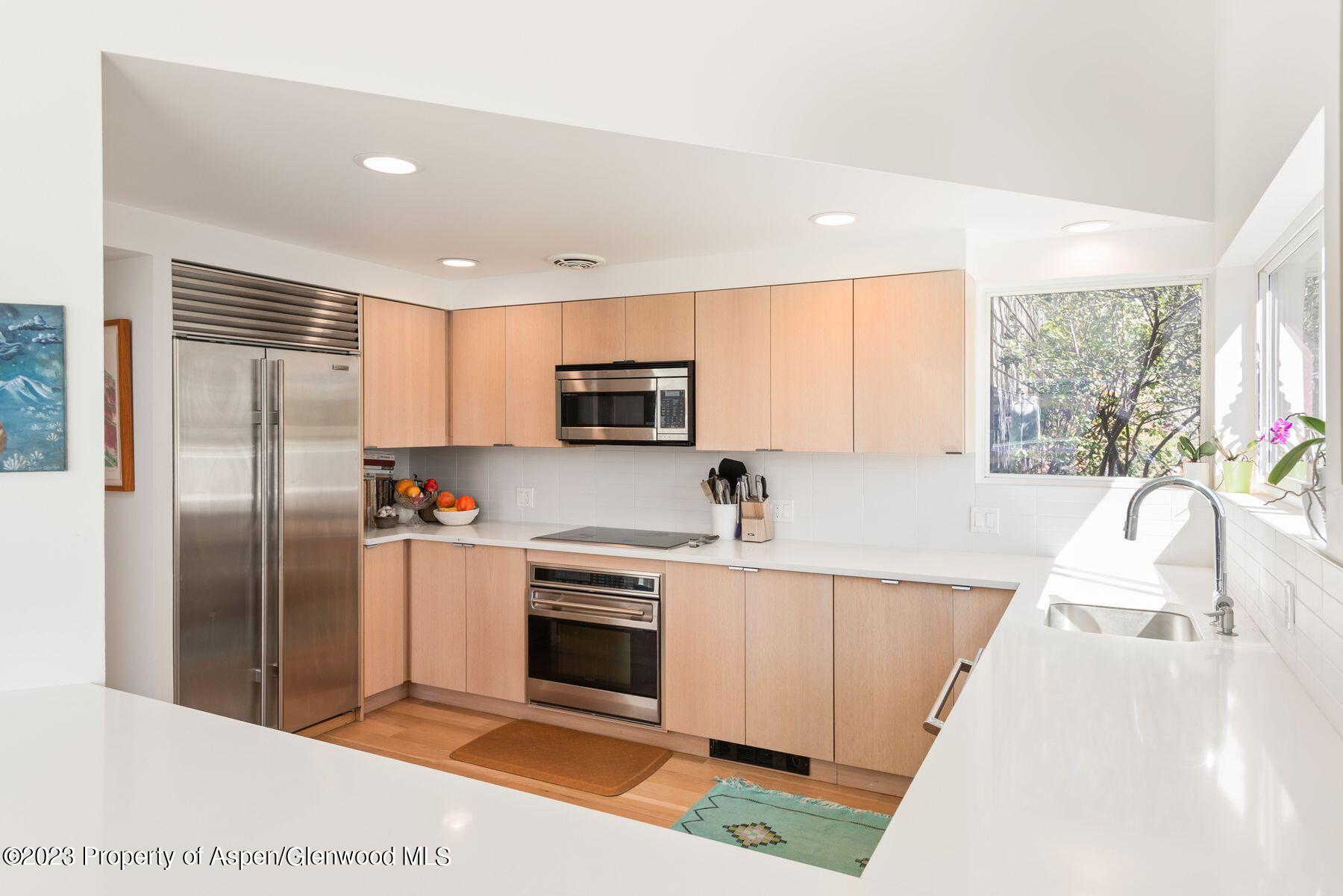 61 Oak Ridge Road Snowmass Village, CO 81615 - Photo 20 of 48 a large kitchen with stainless steel appliances granite countertop a refrigerator a sink a stove top oven a counter space and cabinets
