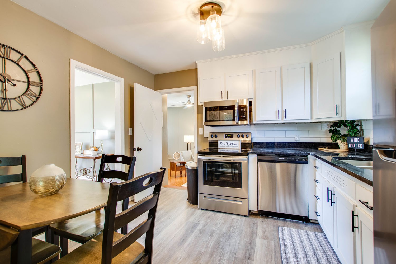 604 Cardinal Drive Murfreesboro, TN 37130 - Photo 8 of 16 a kitchen with stainless steel appliances a stove a sink dishwasher a microwave oven with a dining table and chairs with wooden floor