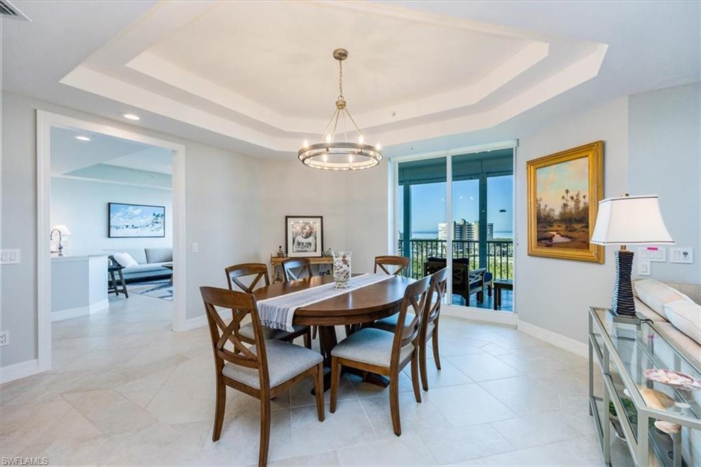 295 Grande Way, Unit 702 Naples, FL 34110 - Photo 11 of 31 a view of a dining room with furniture and a chandelier
