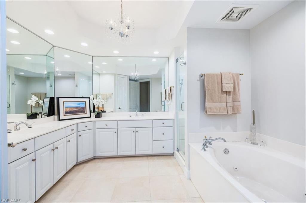 295 Grande Way, Unit 702 Naples, FL 34110 - Photo 16 of 31 a large bathroom with a large tub sink vanity granite and mirror