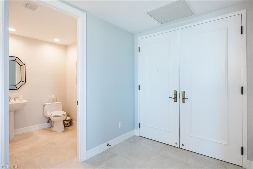 295 Grande Way, Unit 702 Naples, FL 34110 - Photo 23 of 31 a bathroom with a granite countertop toilet and a shower