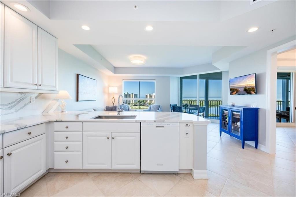 295 Grande Way, Unit 702 Naples, FL 34110 - Photo 7 of 31 a kitchen with white cabinets and sink