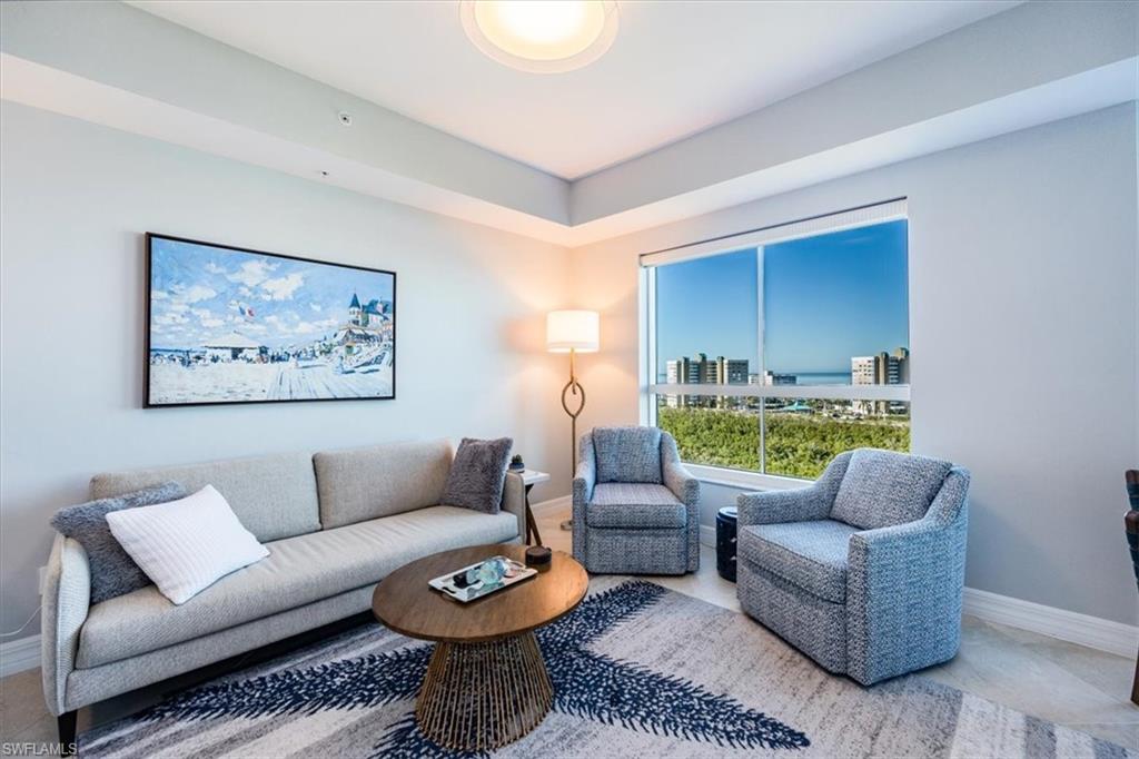 295 Grande Way, Unit 702 Naples, FL 34110 - Photo 9 of 31 a living room with furniture a rug and a wall painting