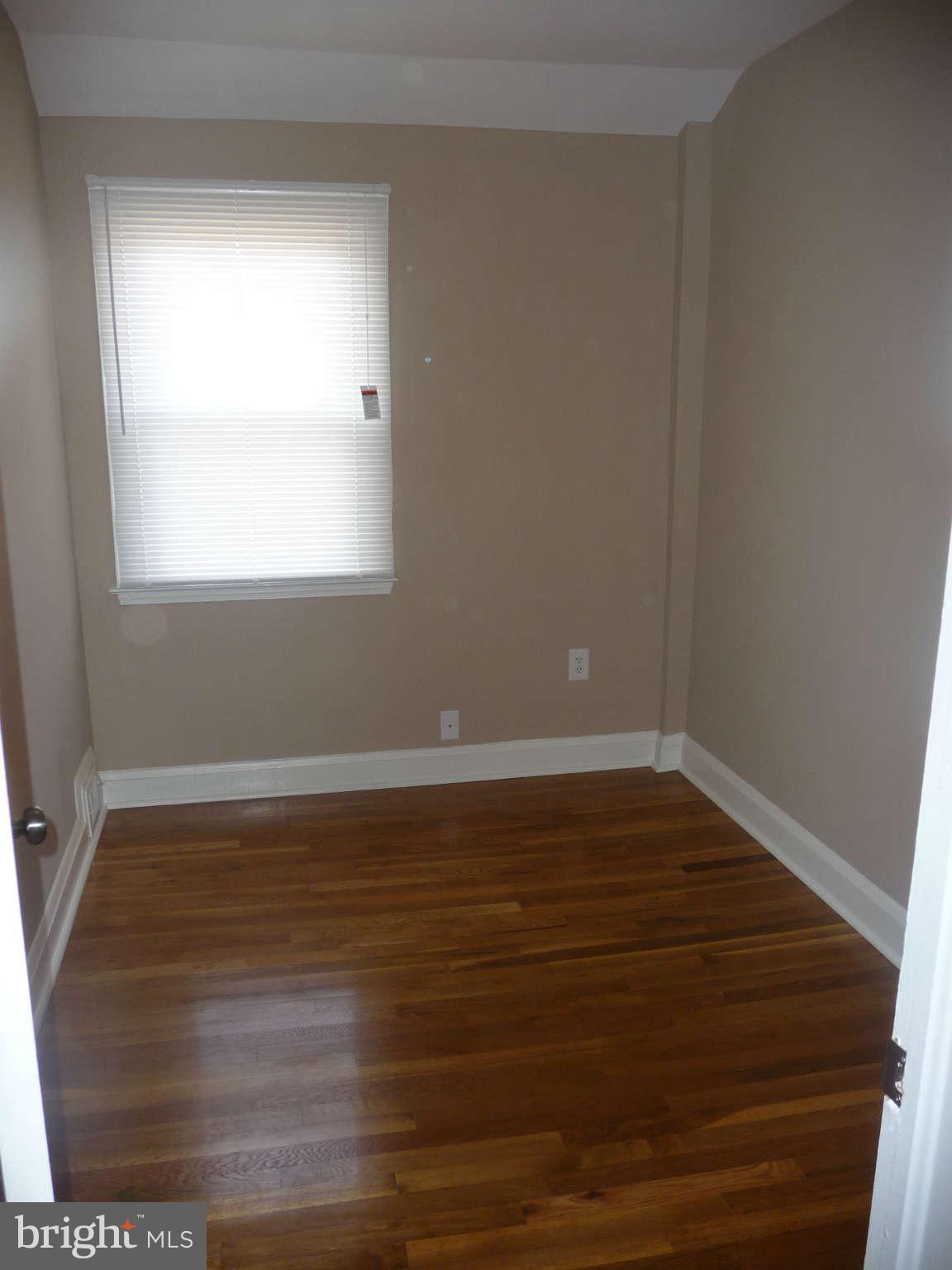 1018 Witherspoon Road Baltimore, MD 21212 - Photo 13 of 19 a view of an empty room with wooden floor and a window