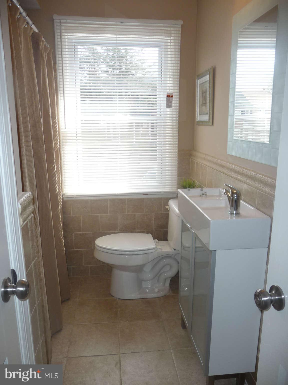 1018 Witherspoon Road Baltimore, MD 21212 - Photo 9 of 19 a bathroom with a sink a toilet and a shower