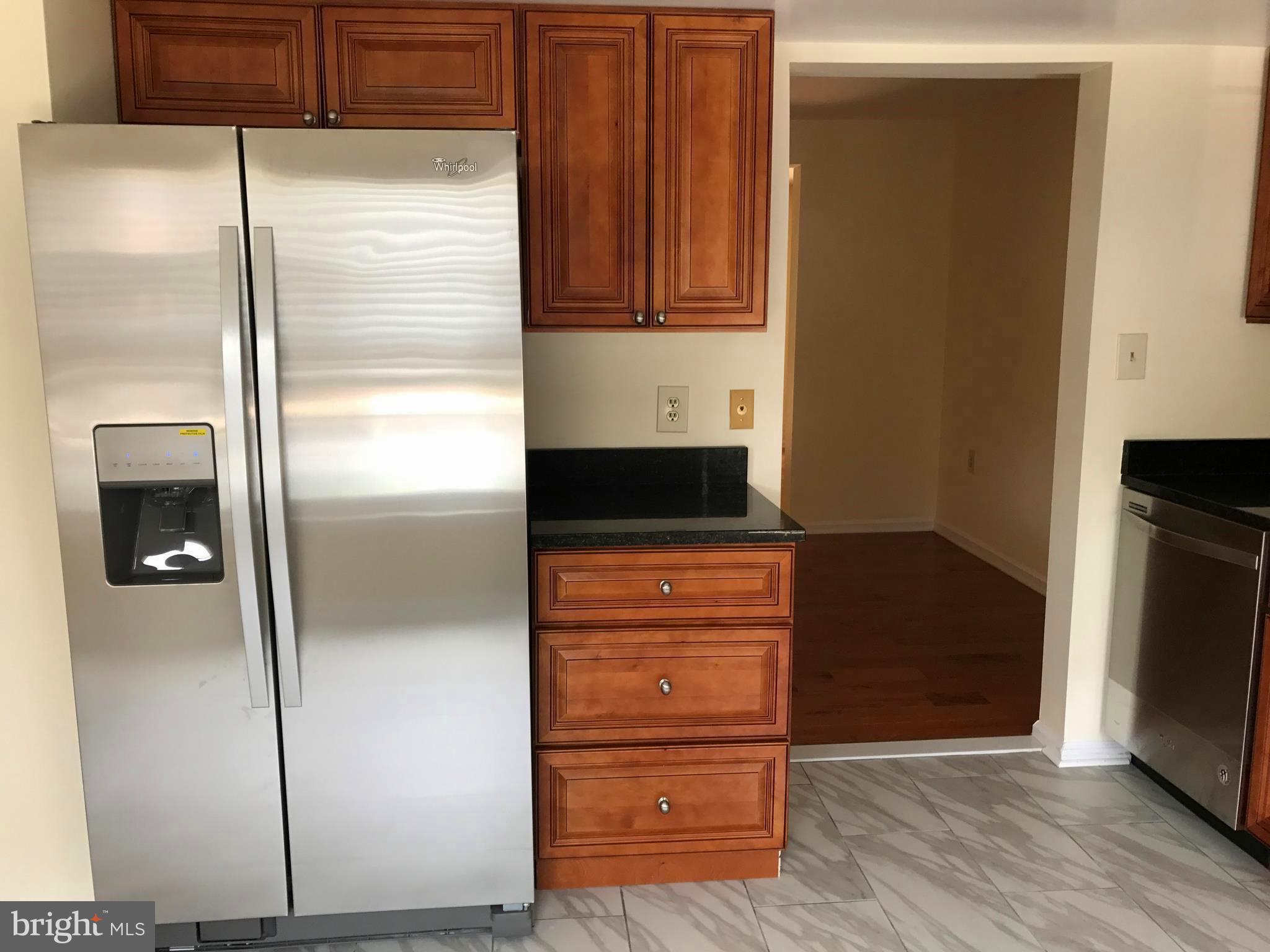 10504 Grove Ridge Place, Unit 48 Rockville, MD 20852 - Photo 6 of 30 a kitchen with a refrigerator and cabinets