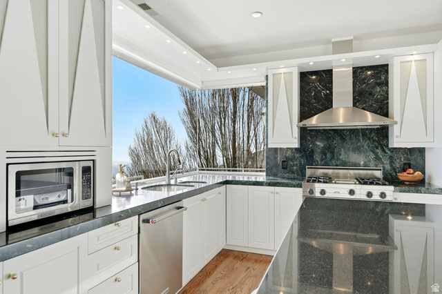 1878 East Ridge Point Drive Bountiful, UT 84010 - Photo 16 of 92 Kitchen featuring dark stone counters, stainless steel appliances, white cabinetry, recessed lighting, and decorative backsplash