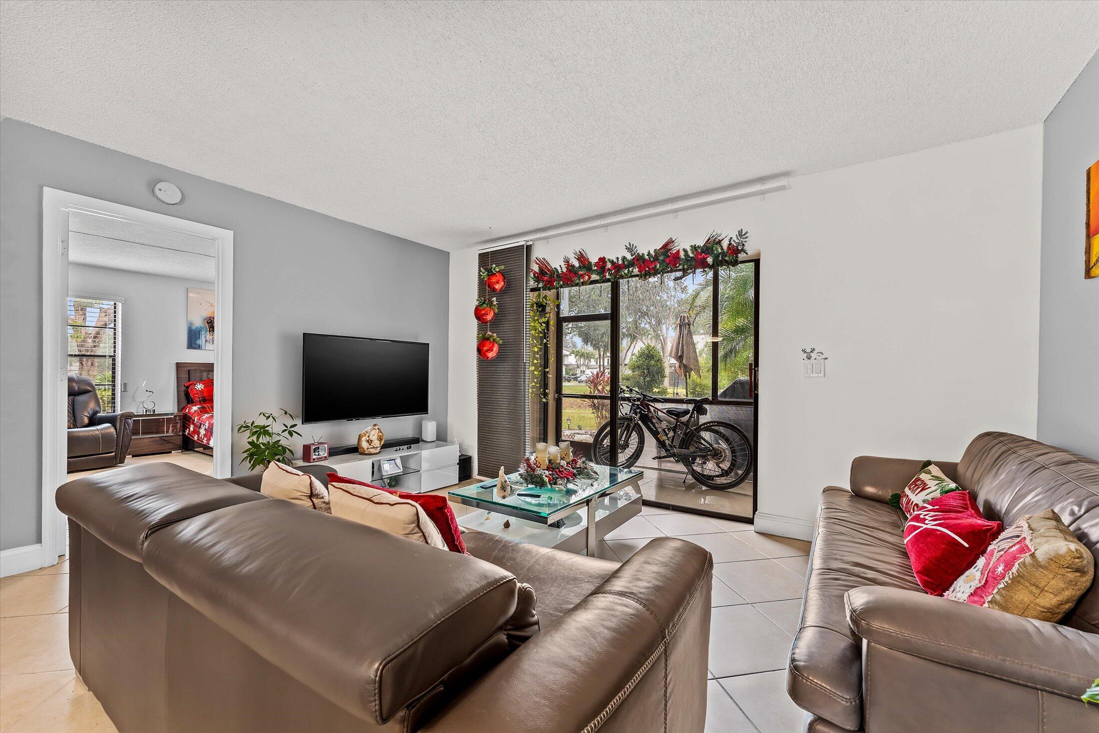 23466 Lyons Road, Unit 501 Boca Raton, FL 33428 - Photo 11 of 40 a living room with furniture and a flat screen tv