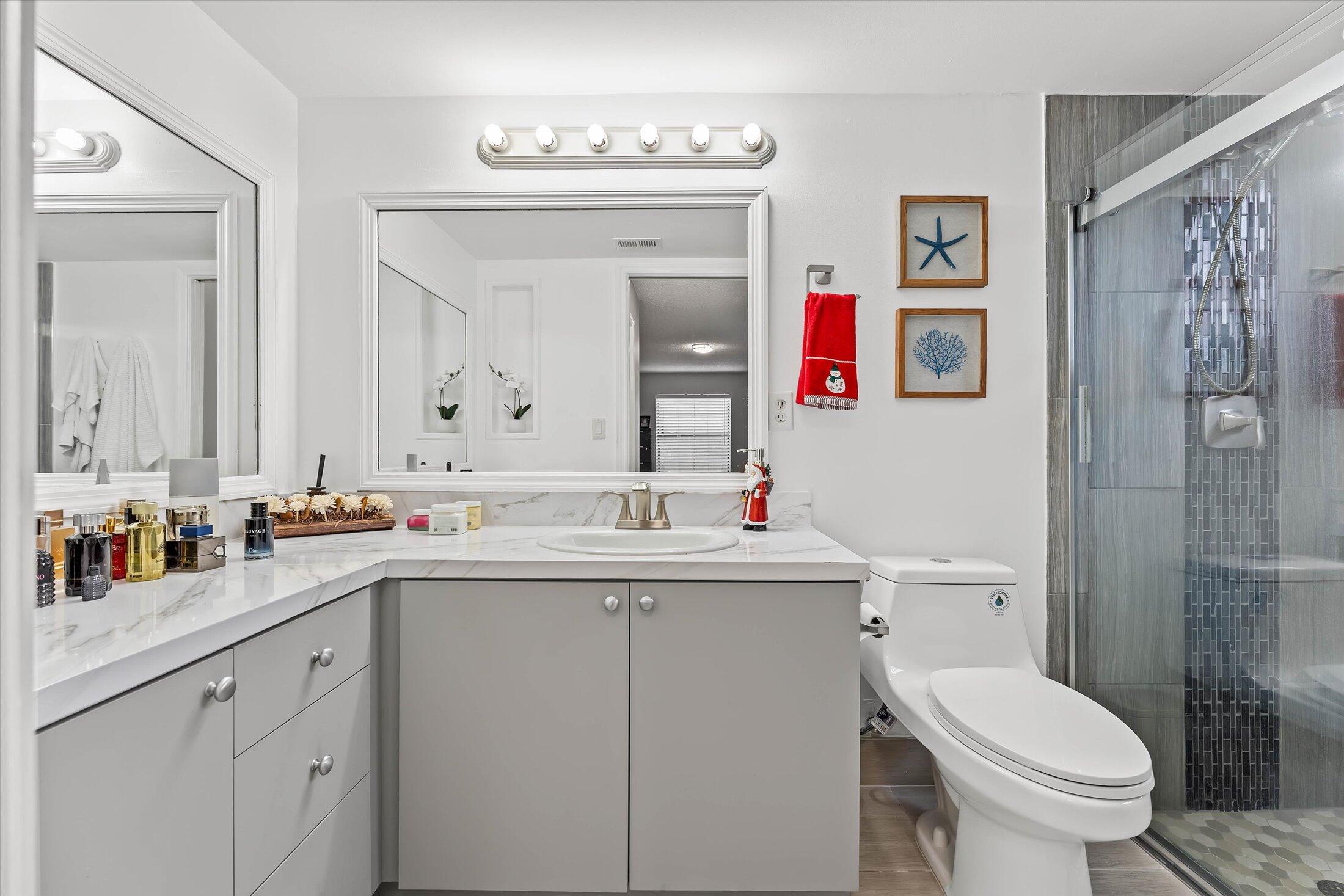 23466 Lyons Road, Unit 501 Boca Raton, FL 33428 - Photo 18 of 40 a bathroom with a toilet sink and mirror