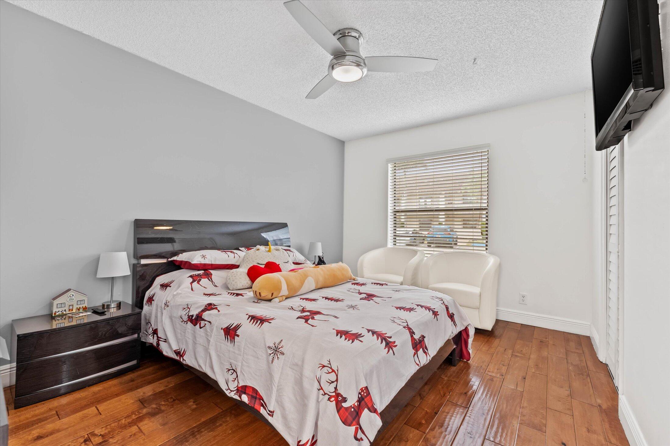 23466 Lyons Road, Unit 501 Boca Raton, FL 33428 - Photo 21 of 40 a bedroom with a bed and a flat tv screen on dresser