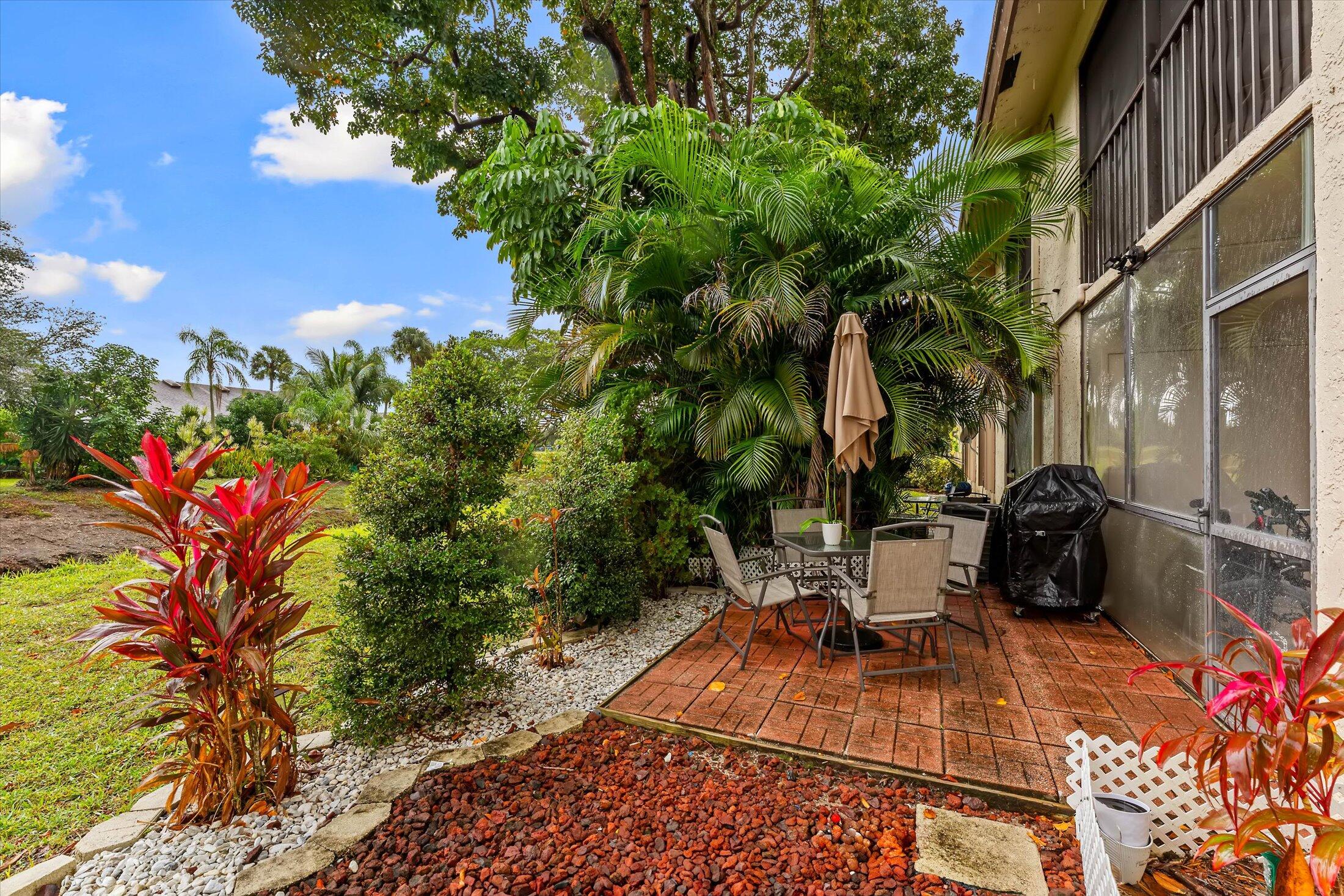 23466 Lyons Road, Unit 501 Boca Raton, FL 33428 - Photo 23 of 40 a view of a patio with table and chairs and potted plants