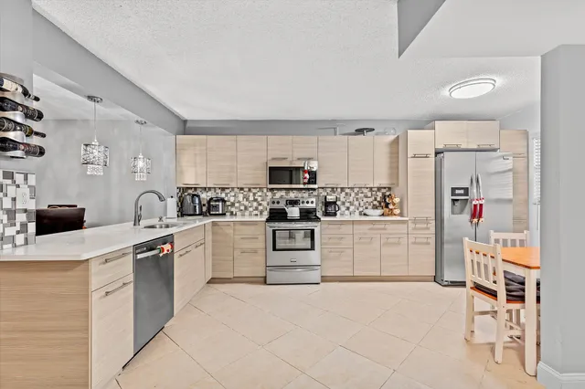 a kitchen with white cabinets and appliances
