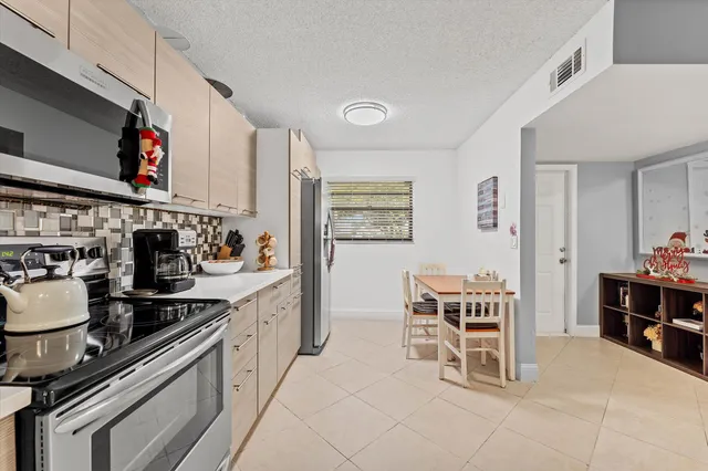 a kitchen with a stove and chairs