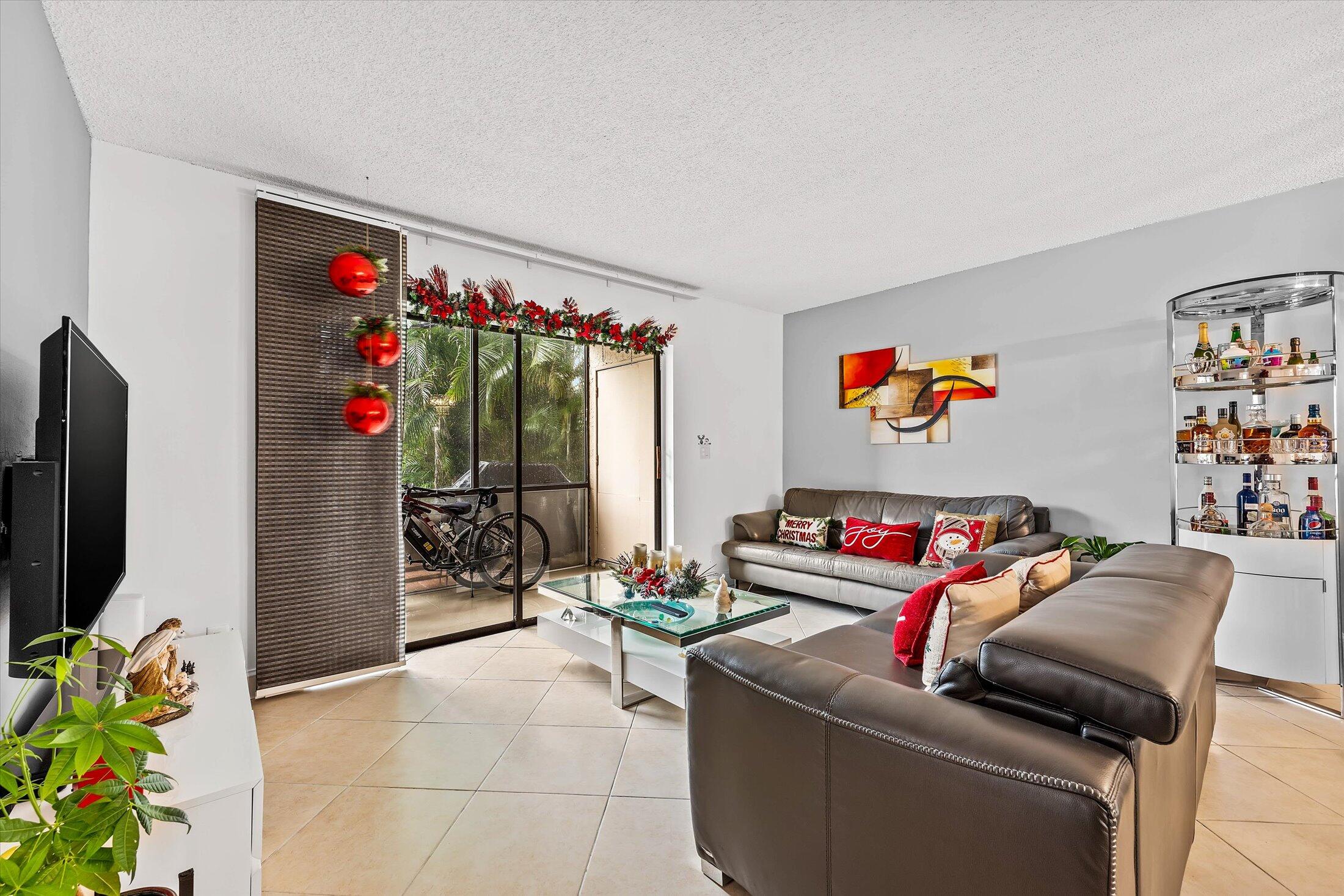 23466 Lyons Road, Unit 501 Boca Raton, FL 33428 - Photo 10 of 40 a living room with furniture toys and a flat screen tv