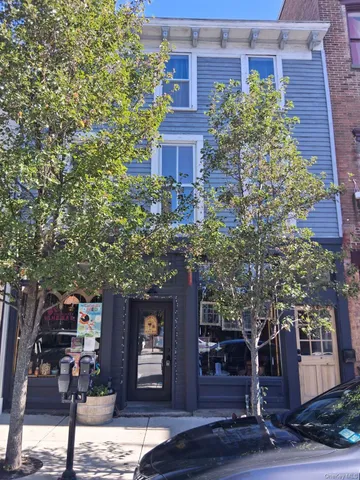 a front view of a building with trees