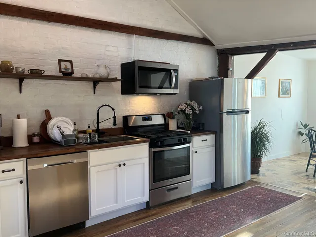 a kitchen with stainless steel appliances granite countertop a stove a microwave and a refrigerator