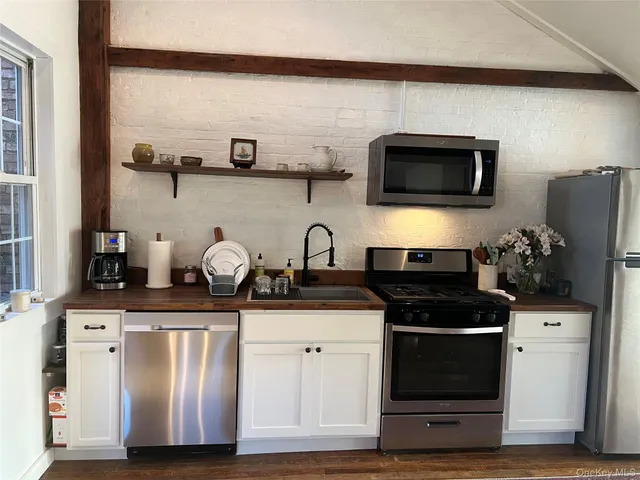 a kitchen with stainless steel appliances granite countertop a stove microwave and refrigerator