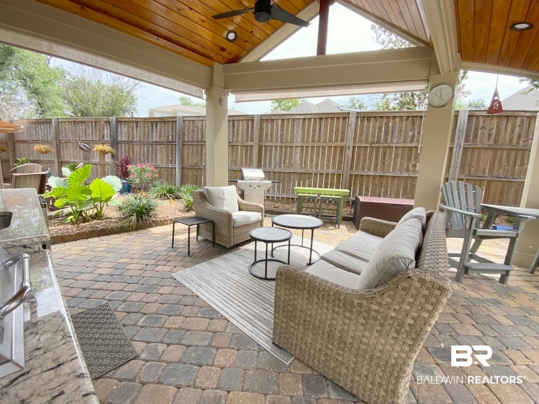 28888 Canal Road, Unit 77 Orange Beach, AL 36561 - Photo 15 of 23 Covered outdoor living space featuring a wood-finish vaulted ceiling with a ceiling fan, integrated lighting, and a built-in outdoor kitchen with a stone-finish countertop and sink