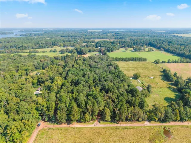 a view of a lush green field with lots of buildings in the background