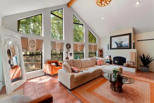 a living room with fireplace furniture and a large window