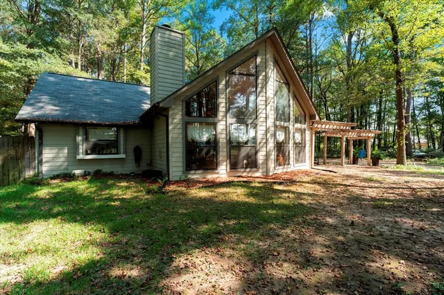 a view of a house with backyard and sitting area