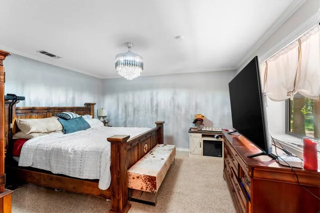 a bedroom with a bed and a flat tv screen on dresser