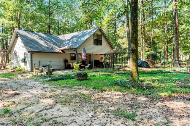 a view of a house with backyard and trees